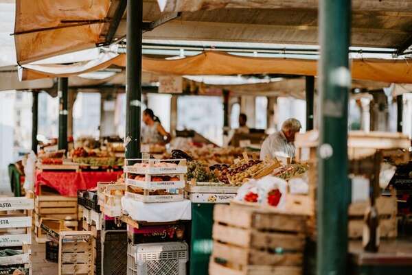 Stacked wooden crates of peaches under outdoor market awnings